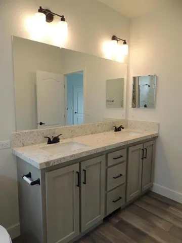 a bathroom with a granite countertop sink and a mirror