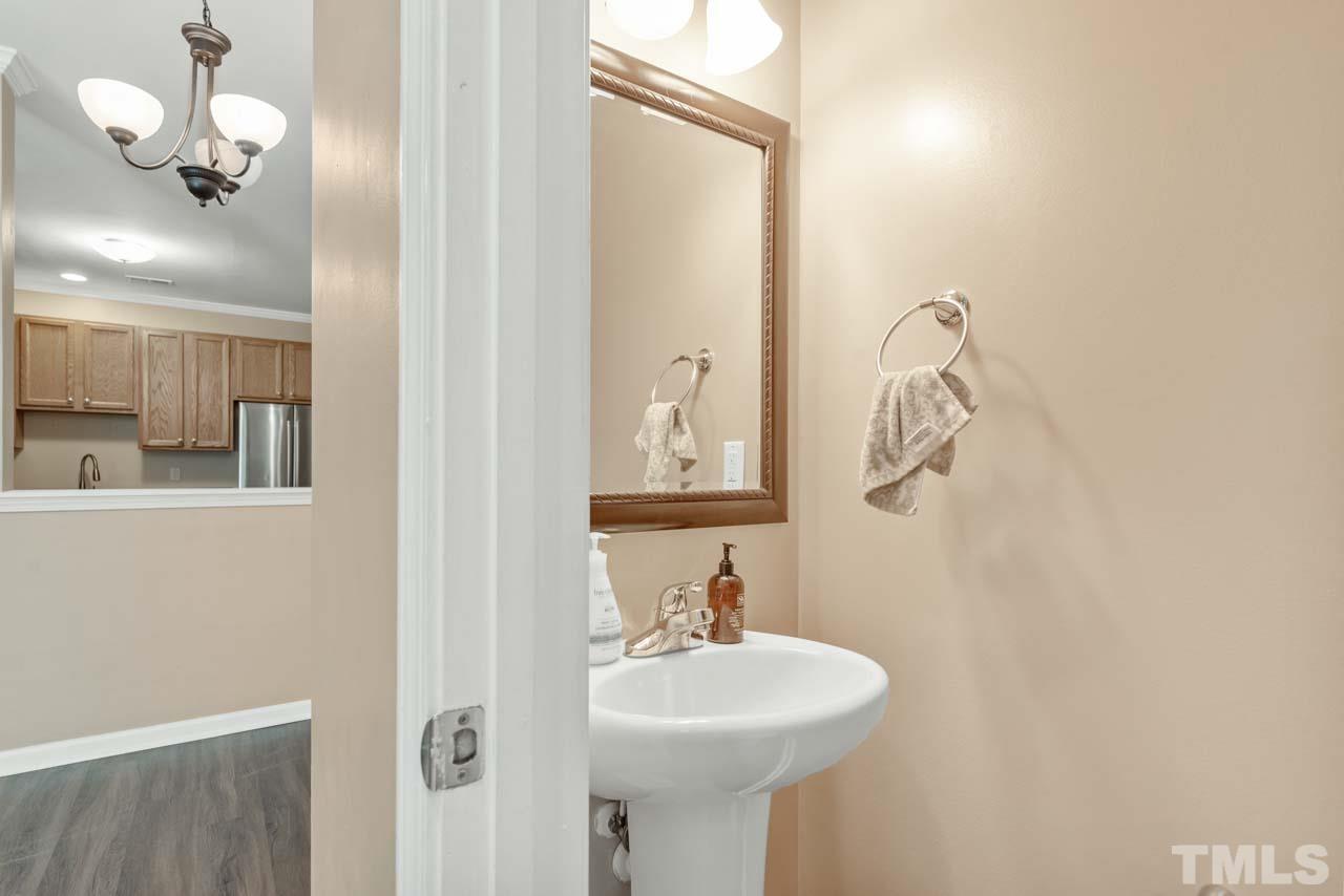 11720 Coppergate Drive, Unit 107 Raleigh, NC 27614 - Photo 4 of 26 a bathroom with a sink a mirror and a light fixture