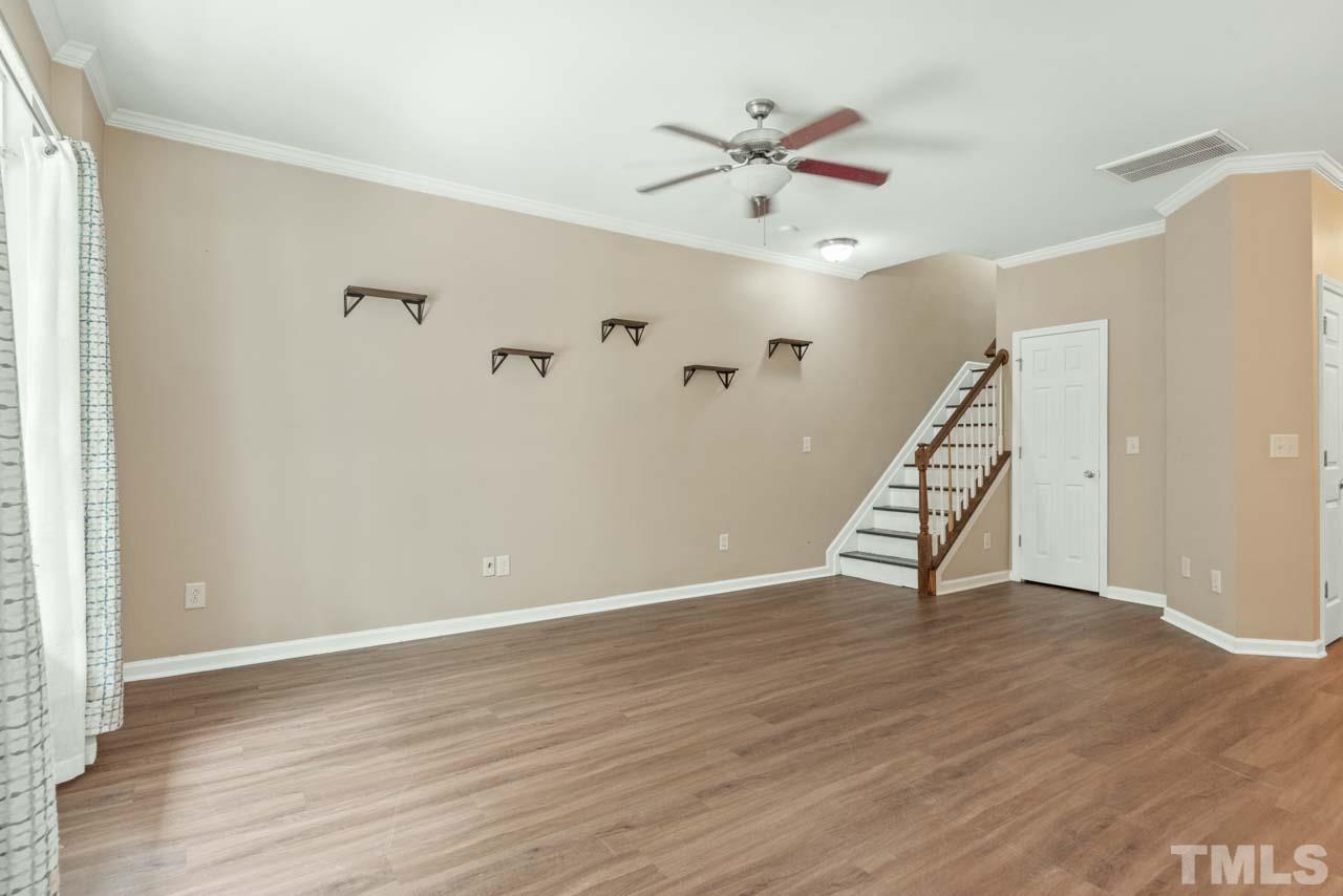 11720 Coppergate Drive, Unit 107 Raleigh, NC 27614 - Photo 5 of 26 an empty room with wooden floor fan and windows