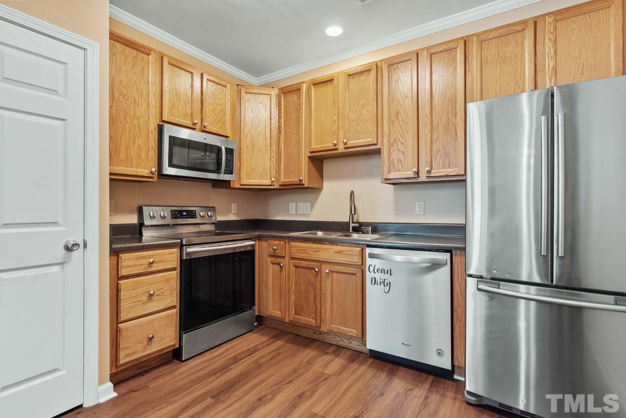 11720 Coppergate Drive, Unit 107 Raleigh, NC 27614 - Photo 9 of 26 a kitchen with stainless steel appliances granite countertop a refrigerator stove microwave and sink
