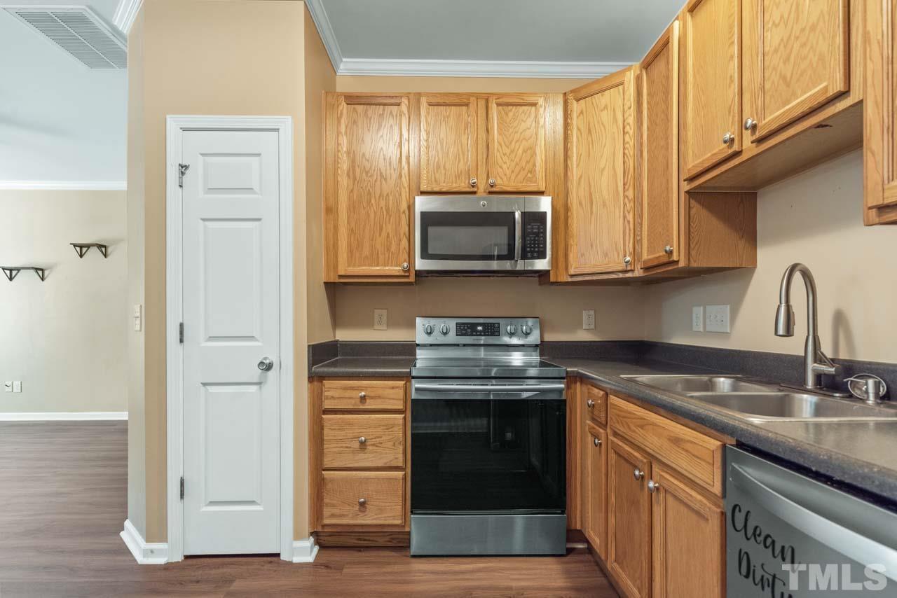 11720 Coppergate Drive, Unit 107 Raleigh, NC 27614 - Photo 10 of 26 a kitchen with stainless steel appliances granite countertop a stove microwave and cabinets