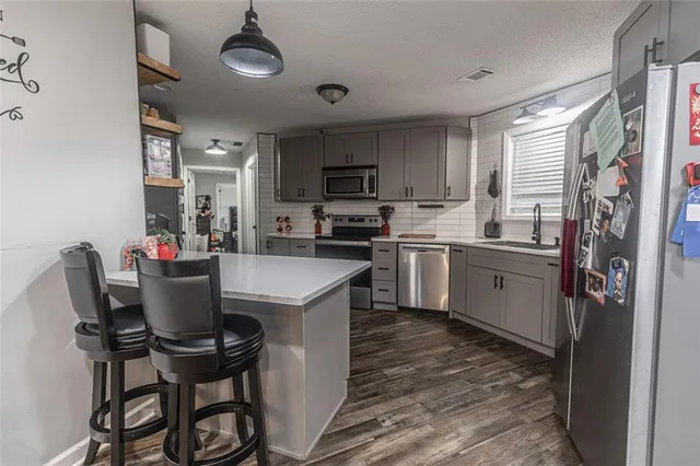 a kitchen with a table chairs refrigerator and microwave