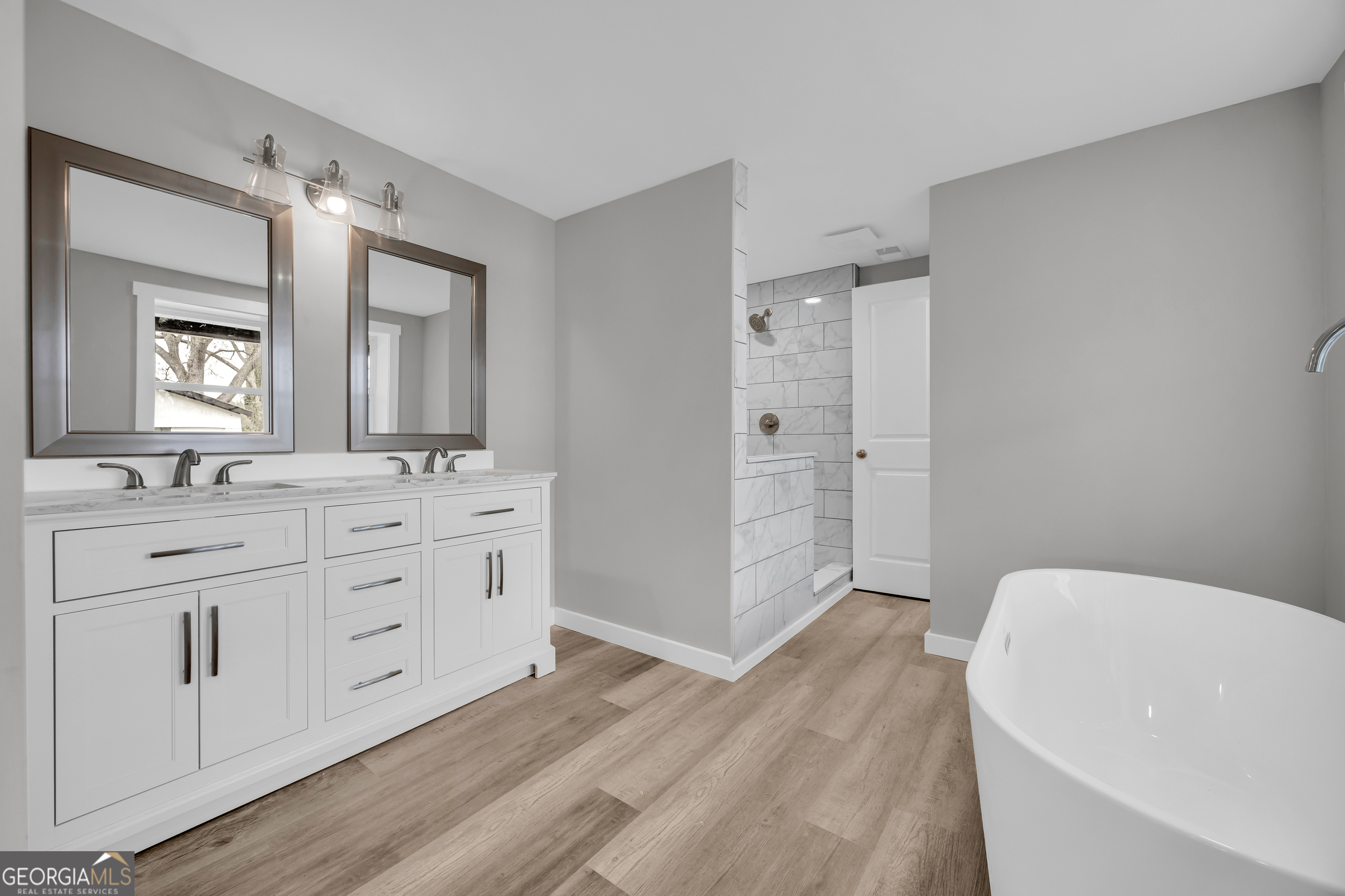 8606 Holly Springs Road Maysville, GA 30558 - Photo 45 of 74 a spacious bathroom with a double vanity sink a mirror and a bathtub