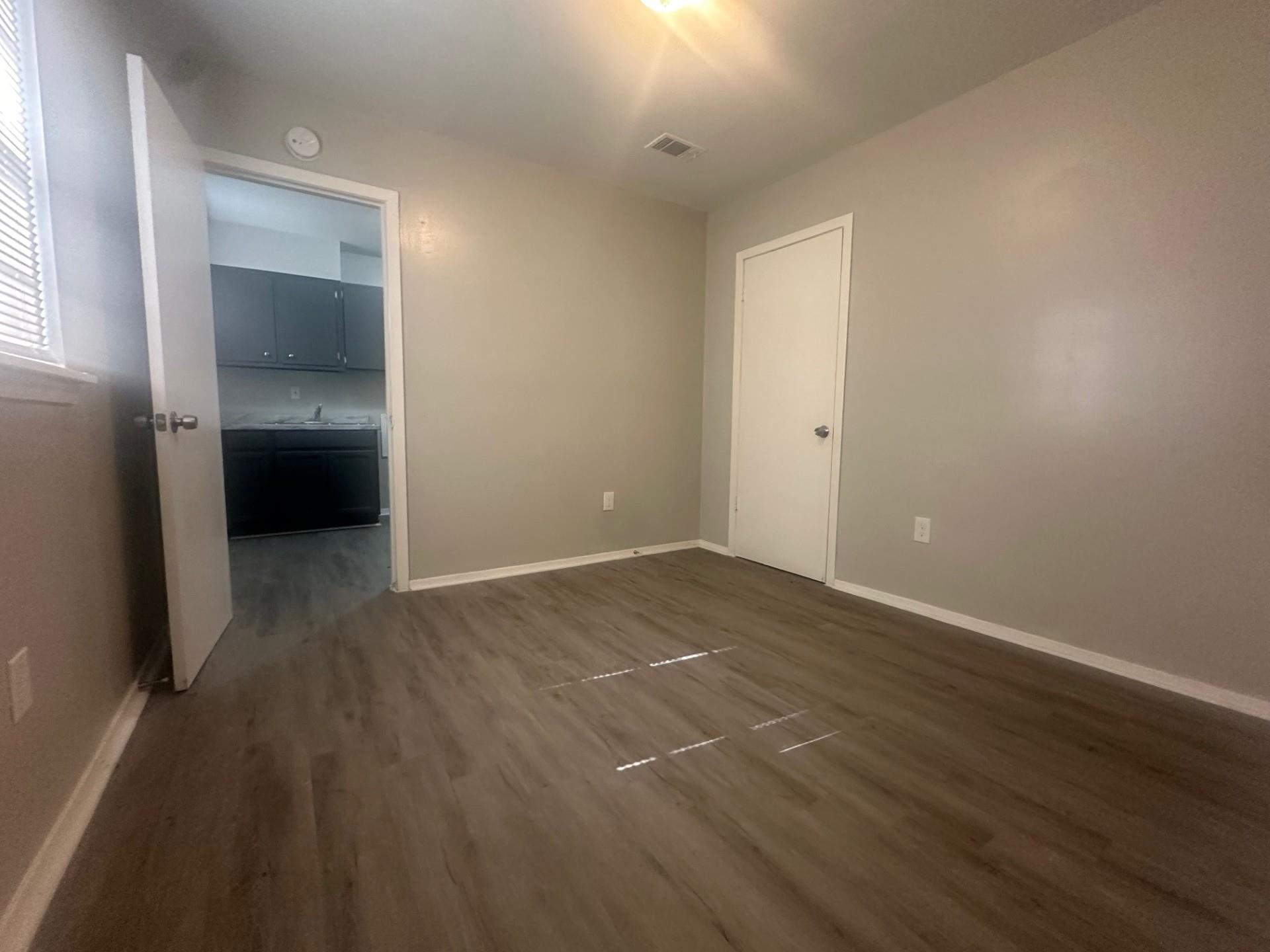 499 Baltimore Street Memphis, TN 38111 - Photo 5 of 9 an empty room with wooden floor and a bathroom