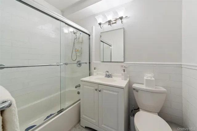 a bathroom with a toilet sink and mirror with bathtub