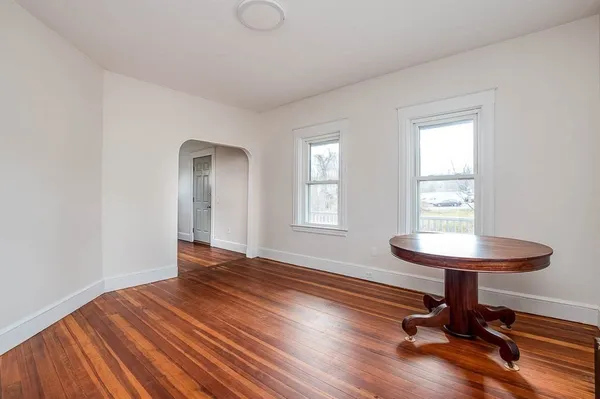 a view of a room with wooden floor lounge chair and windows