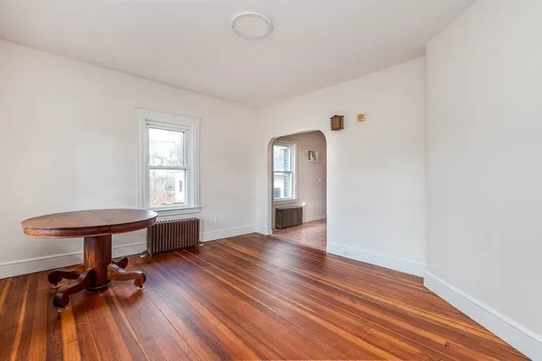 a view of a room with wooden floor table and chairs