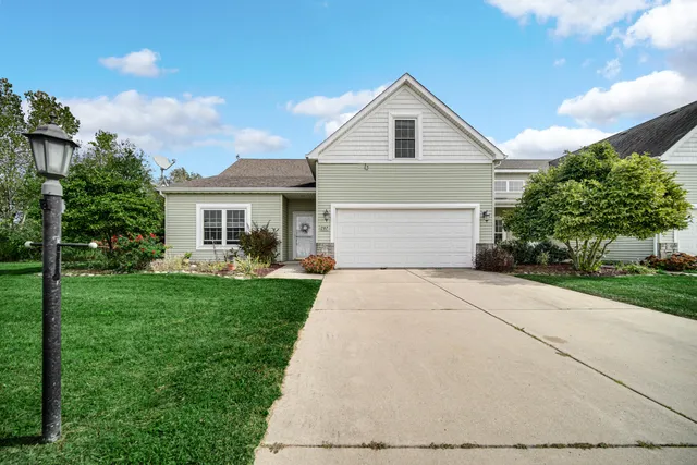 a front view of a house with a yard and trees
