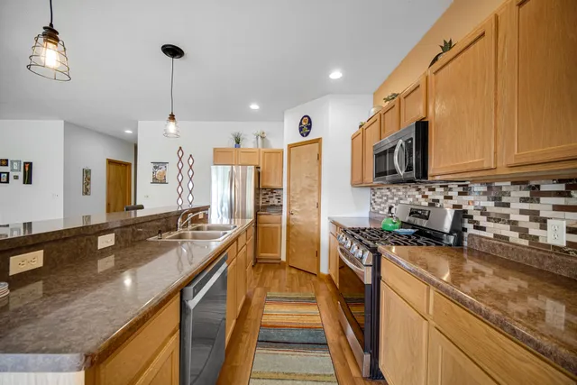 a kitchen with granite countertop a sink a counter top space appliances and cabinets