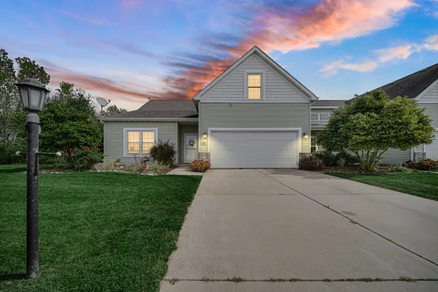 a front view of a house with a yard and trees