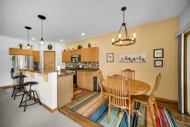 a dining room with furniture a chandelier and wooden floor
