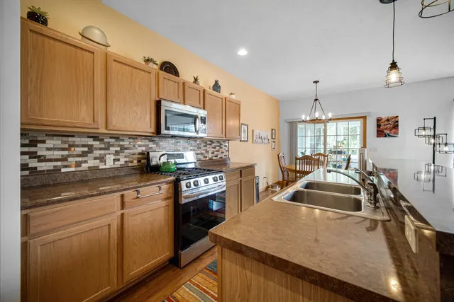 a kitchen with granite countertop a sink a stove and cabinets