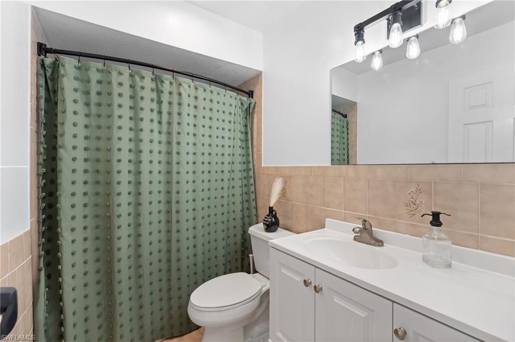 1030 13th Street Southwest Naples, FL 34117 - Photo 12 of 43 a bathroom with a sink a toilet and a mirror