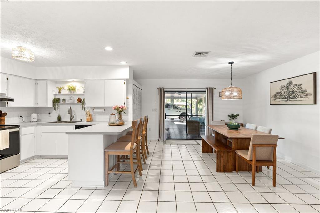 1030 13th Street Southwest Naples, FL 34117 - Photo 13 of 43 a kitchen with a dining table and chairs