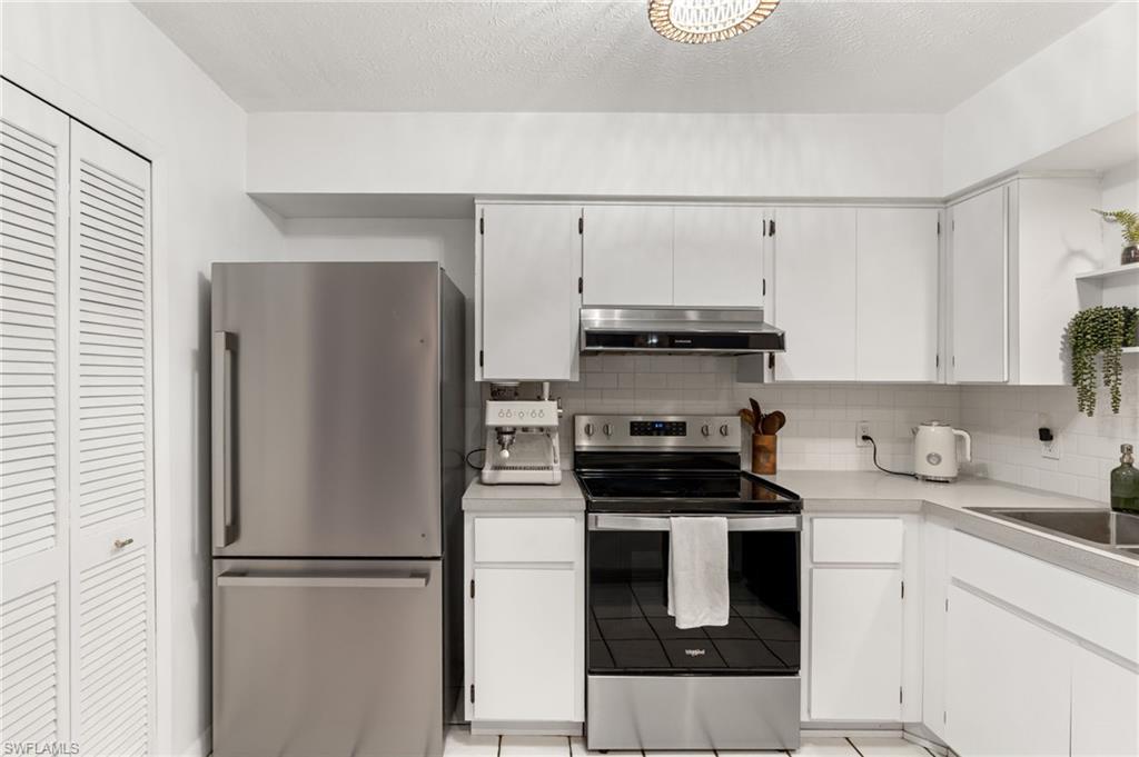 1030 13th Street Southwest Naples, FL 34117 - Photo 15 of 43 a kitchen with stainless steel appliances a refrigerator sink and cabinets
