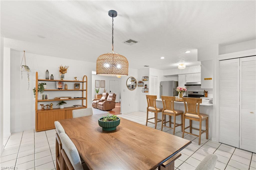 1030 13th Street Southwest Naples, FL 34117 - Photo 18 of 43 a view of a dining room and livingroom with furniture wooden floor a chandelier