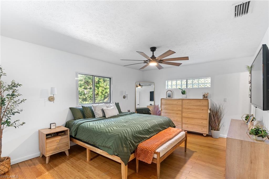 1030 13th Street Southwest Naples, FL 34117 - Photo 20 of 43 a bedroom with a bed and a chandelier