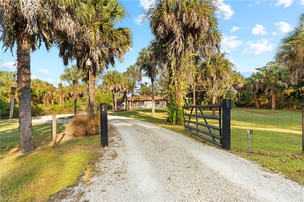 1030 13th Street Southwest Naples, FL 34117 - Photo 3 of 43 a view of swimming pool with a lawn chairs under an umbrella