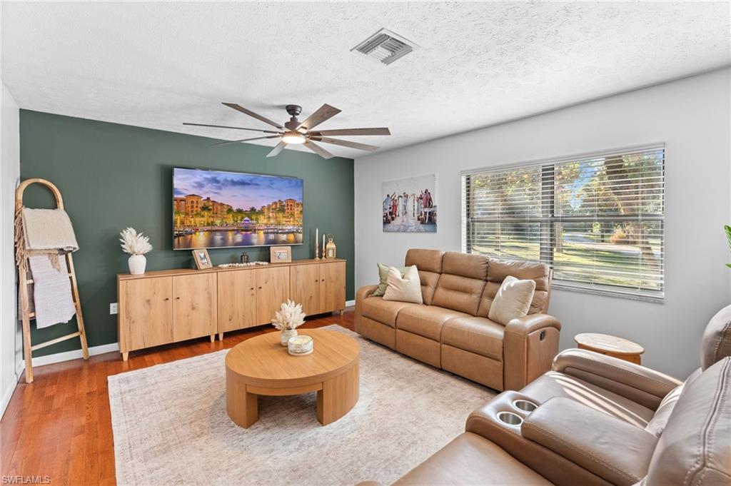 1030 13th Street Southwest Naples, FL 34117 - Photo 6 of 43 a living room with furniture a flat screen tv and a large window