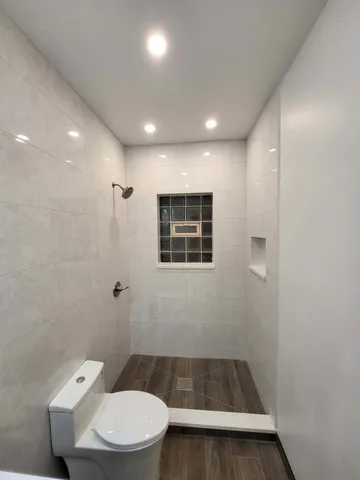 a bathroom with a toilet and a shower