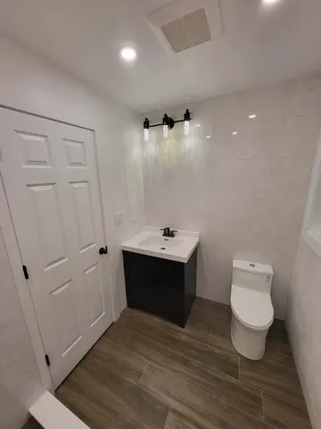 a bathroom with a toilet sink and mirror