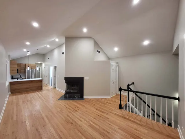 a view of a hallway with wooden floor and a fireplace