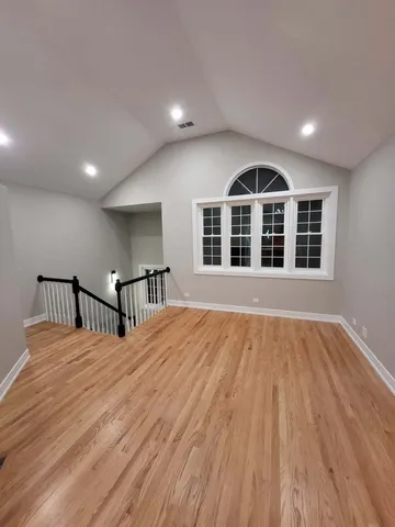 a big room with wooden floor and windows