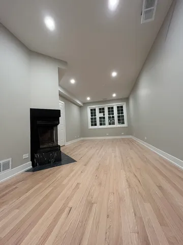 an empty room with wooden floor and a window