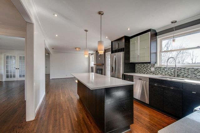 an empty room with wooden floor chandelier fan and windows