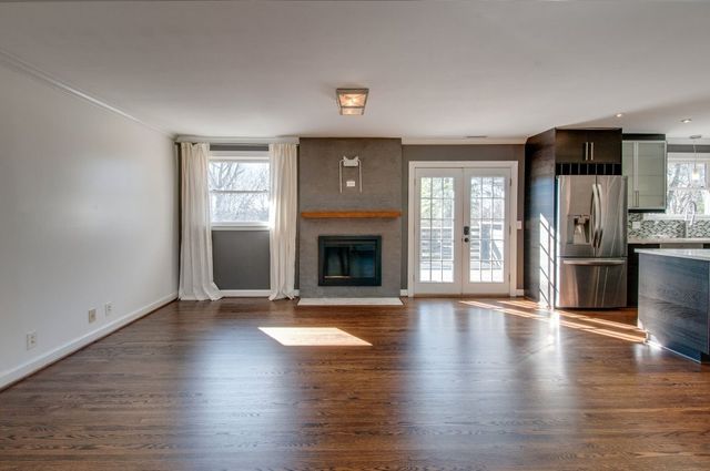 a kitchen with stainless steel appliances granite countertop a refrigerator a stove a sink and a oven with wooden floor