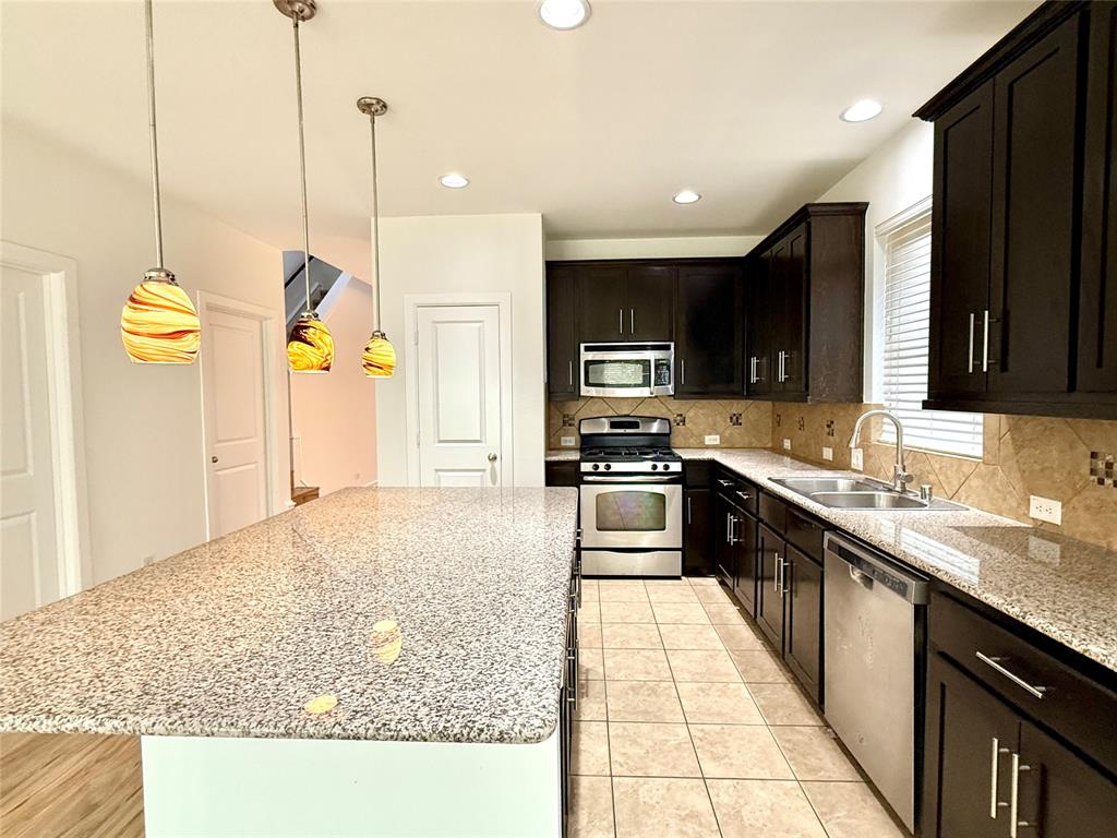 5737 Yorkshire Road McKinney, TX 75070 - Photo 18 of 19 a kitchen with stainless steel appliances granite countertop a sink a stove top oven a granite counter top and utility