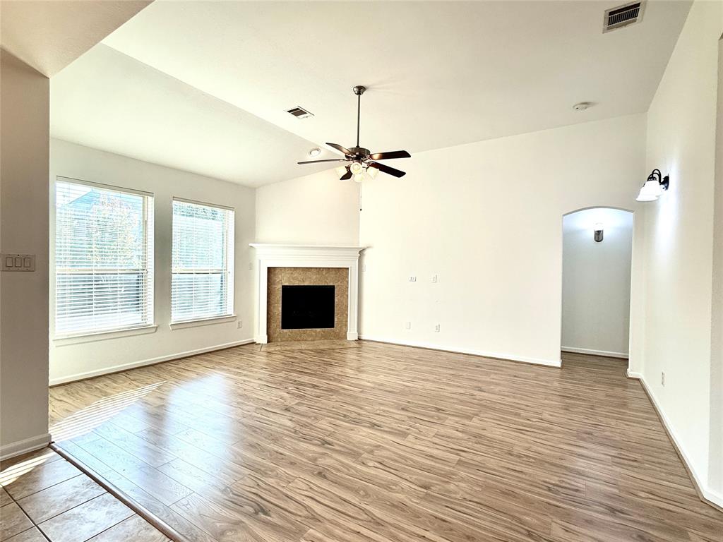 5737 Yorkshire Road McKinney, TX 75070 - Photo 4 of 19 a view of a livingroom with wooden floor a ceiling fan and windows