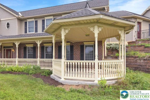 a view of a house with a small yard and wooden fence