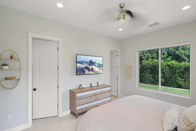 a bedroom with a bed and a painting on the wall