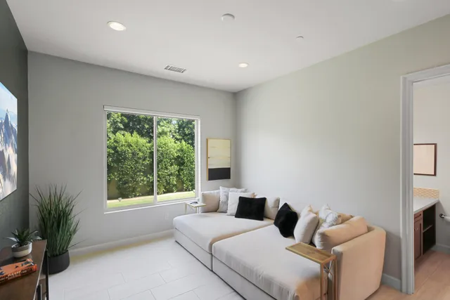 a bedroom with furniture and a large window