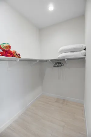 a view of walk in closet with clothes