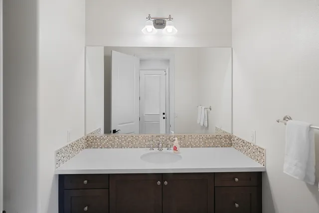 a bathroom with a granite countertop sink and a mirror