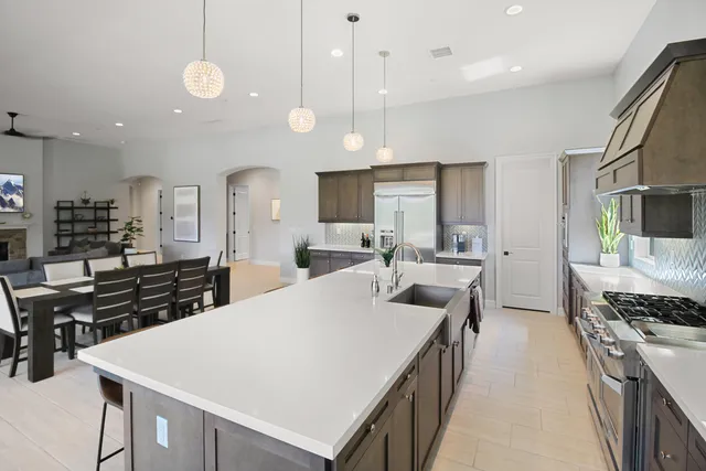 a large kitchen with kitchen island a stove a sink a center island and couches