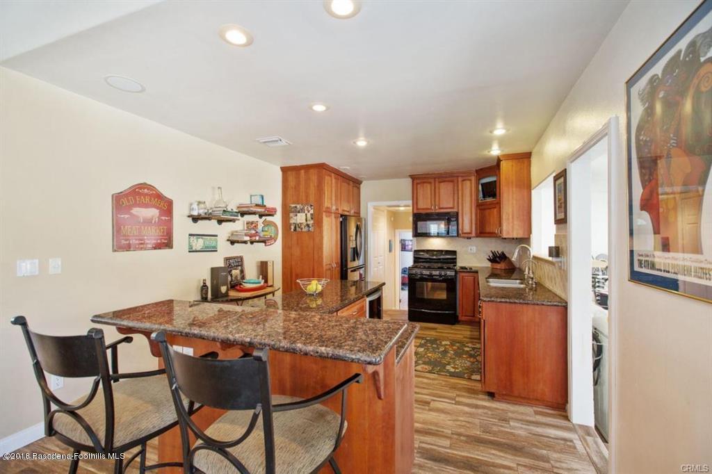 2340 Caldero Lane Montrose, CA 91020 - Photo 6 of 10 a kitchen with stainless steel appliances granite countertop a stove refrigerator and a refrigerator with wooden floor