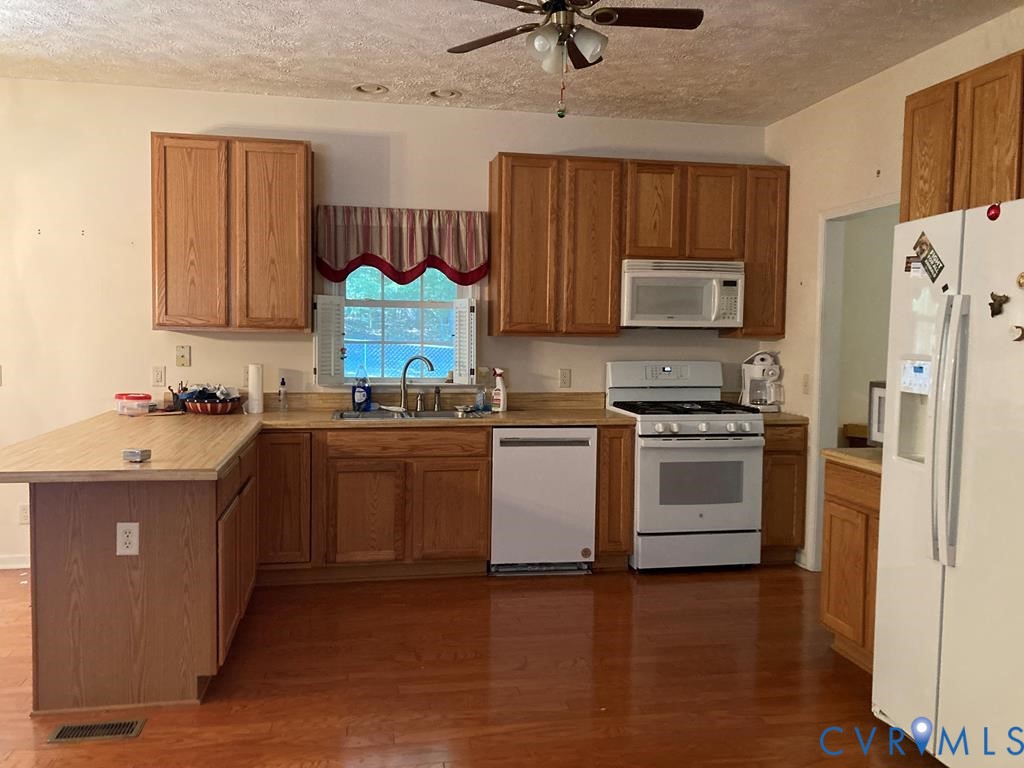 514 Wallace Street Warsaw, VA 22572 - Photo 10 of 25 Kitchen with white appliances, a peninsula, dark w