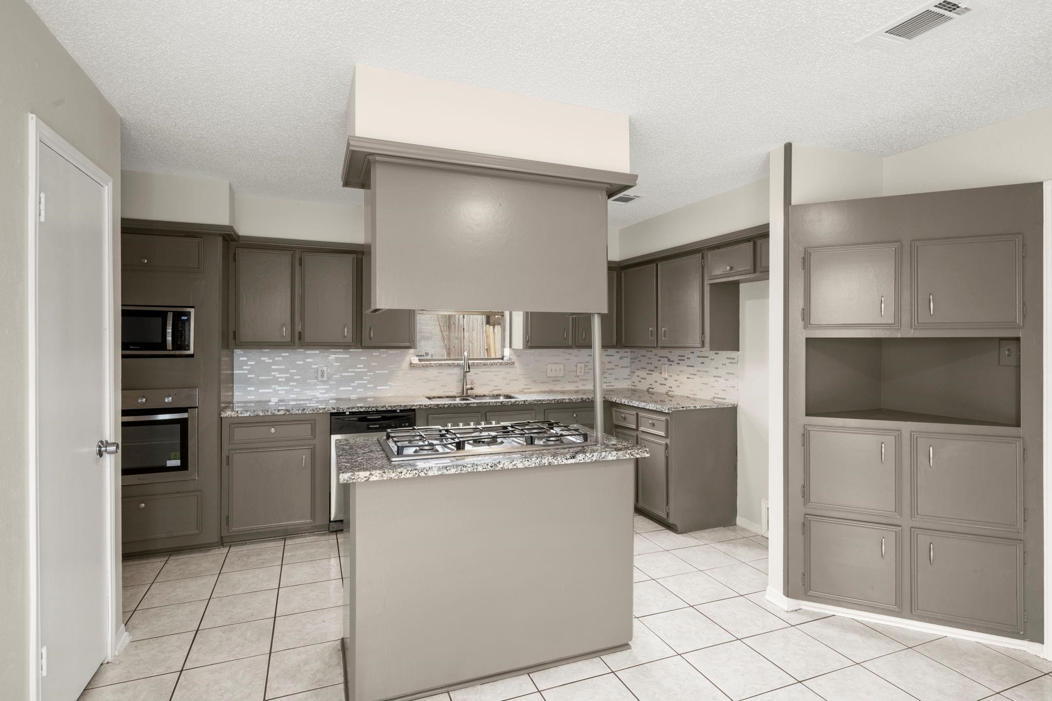 11718 Ridge Run Drive Houston, TX 77064 - Photo 5 of 17 a kitchen with stainless steel appliances granite countertop a stove a refrigerator and a sink