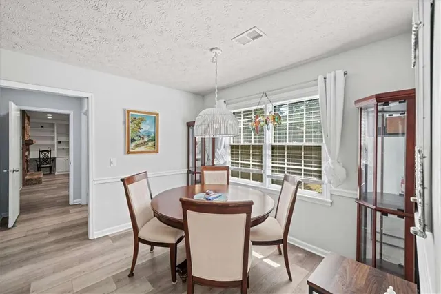 a dining room with furniture window and wooden floor