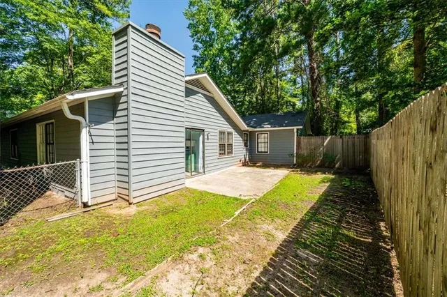 a view of a house with backyard and wooden fence