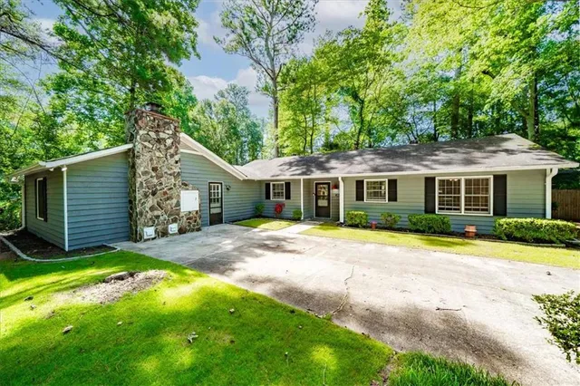 a view of a yard in front of a house with large tree