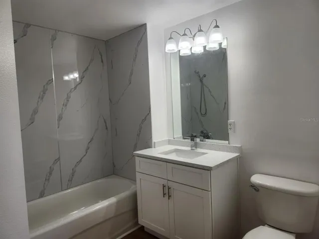 a bathroom with a sink toilet tub and shower