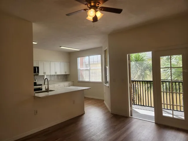 a kitchen with stainless steel appliances granite countertop a sink dishwasher a stove and a refrigerator with wooden floor