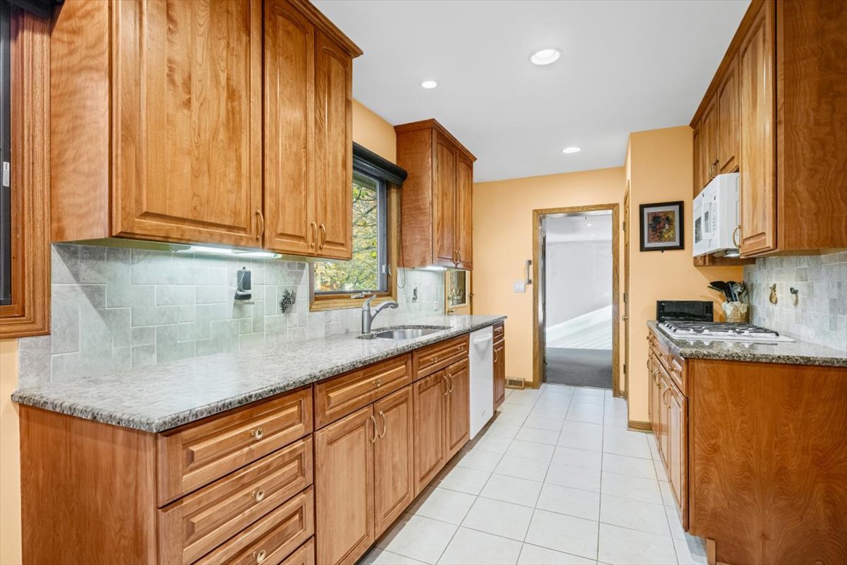 3296 Brook Road Highland Park, IL 60035 - Photo 6 of 21 a kitchen with stainless steel appliances granite countertop a sink and a refrigerator