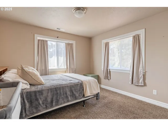 a bed sitting in a bedroom next to a window