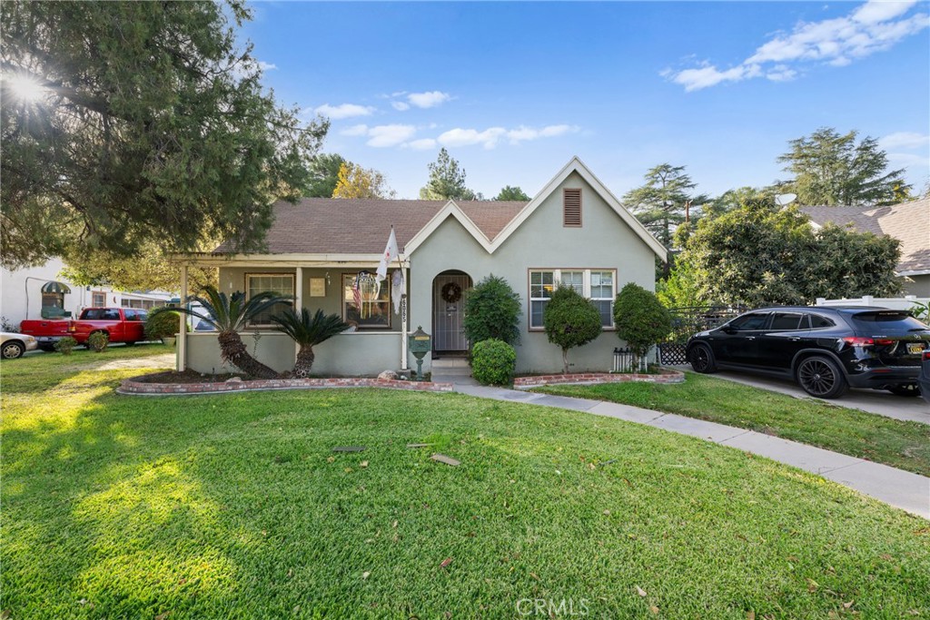 a front view of a house with a garden and trees
