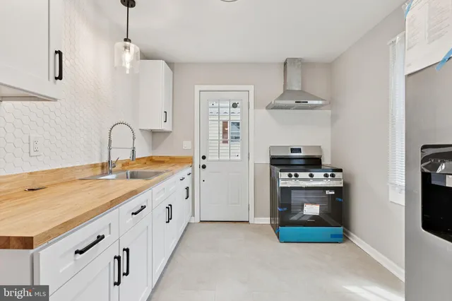 a kitchen with kitchen island white cabinets and refrigerator
